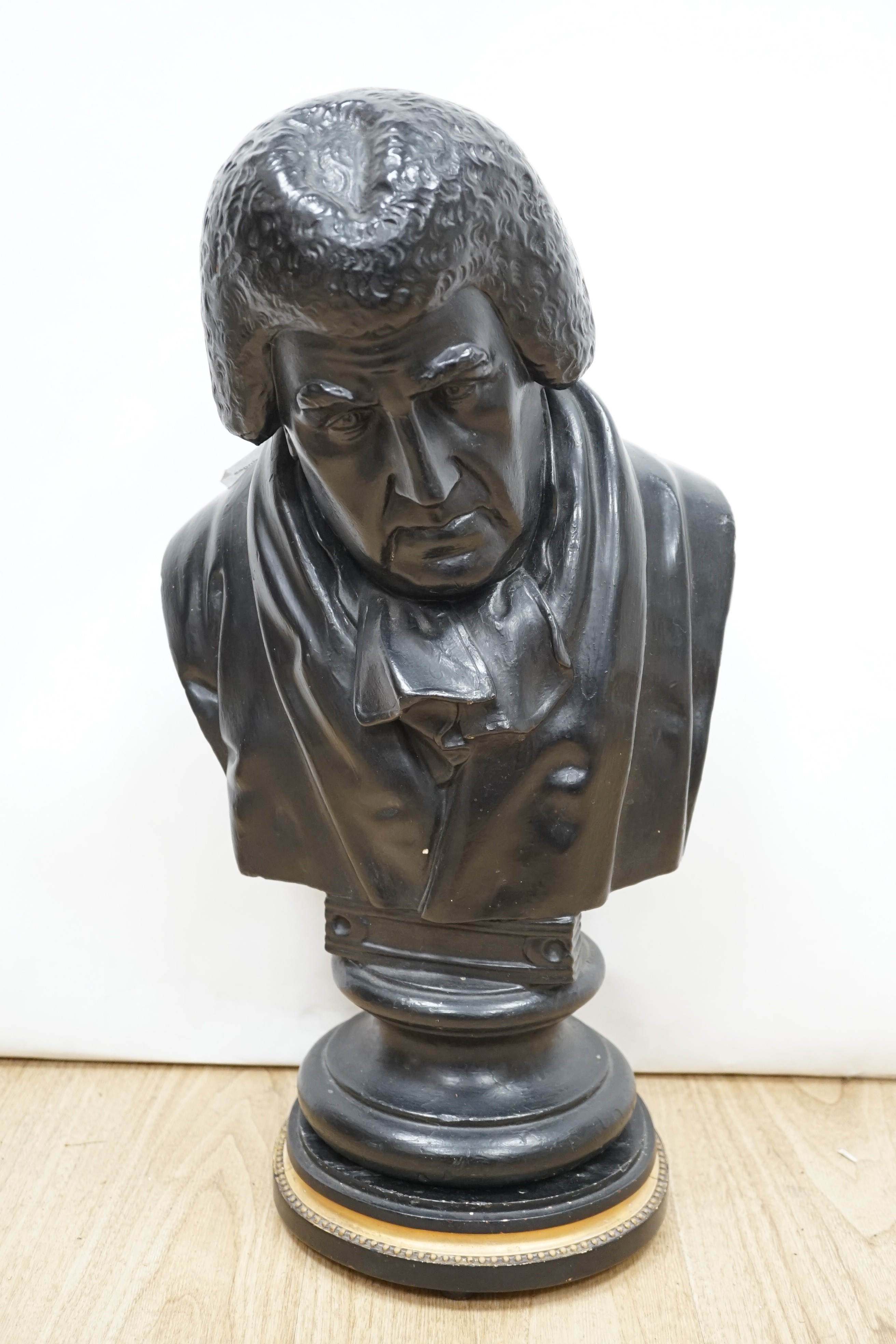 A black painted plaster bust of a judge, inscribed 1826, 49cms high.